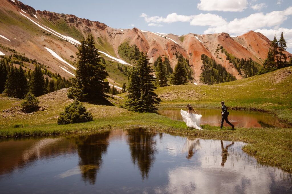 Bride and groom running in the red mountains