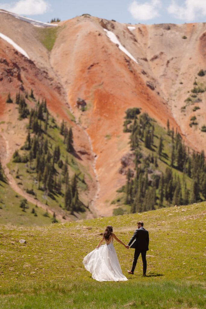 Couple walking off into the mountains on their wedding day