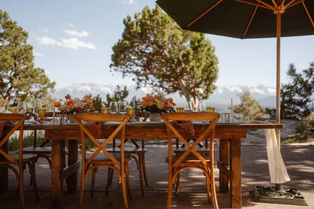 View of outdoor patio wedding dinner spread with mountains in the distance