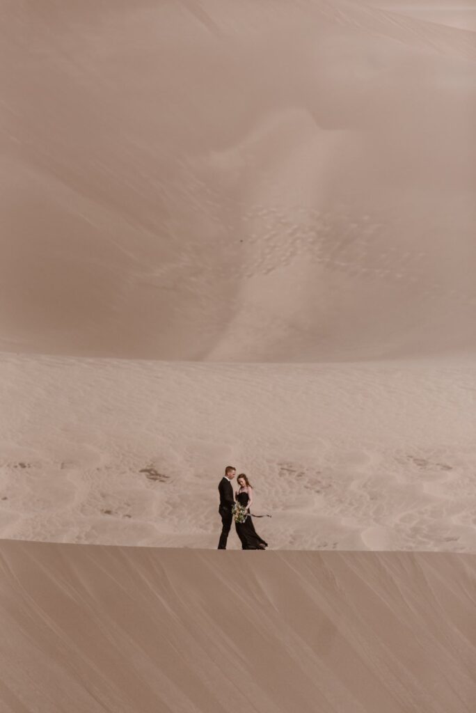 Couple on the edge of a sand dune in Colorado on their wedding day