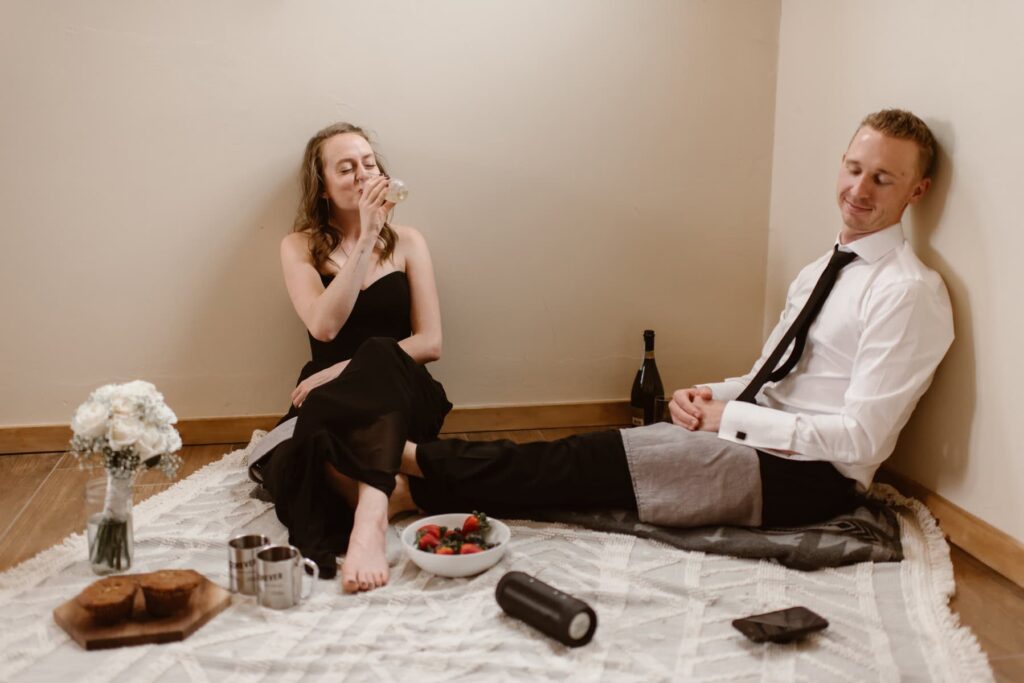 Couple sharing a picnic on their wedding day inside