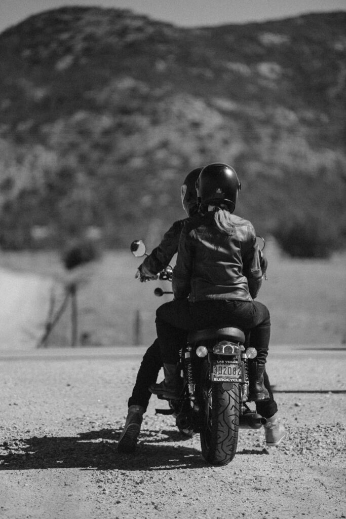 Motorbike couple riding off into the mountains during photoshoot