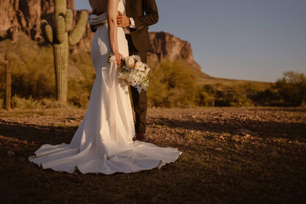 Bride and groom in the desert with long wedding dress train