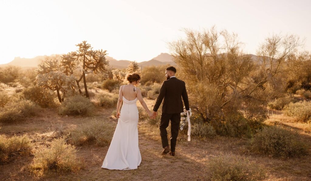 Couple walking through desert landscape on their wedding day at Lost Dutchman State Park