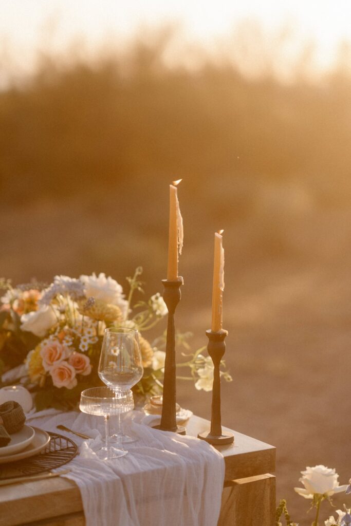 Candles burning at an outdoor elopement dining table