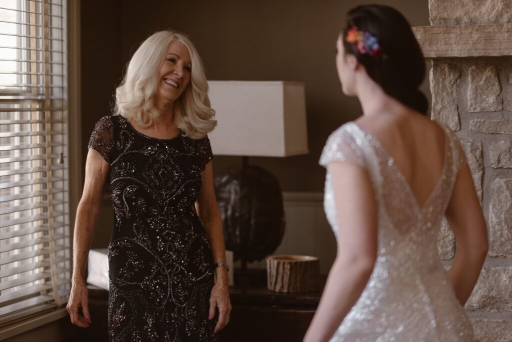 Bride's mother helping her with her dress inside living area at Sopris House