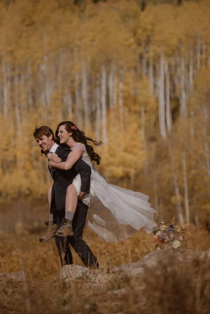 Fall wedding photos of bride and groom running through the forest