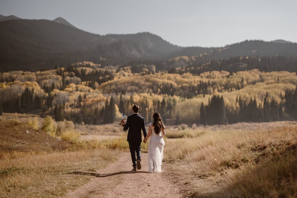 Couple walking off into the Colorado mountains on their wedding day