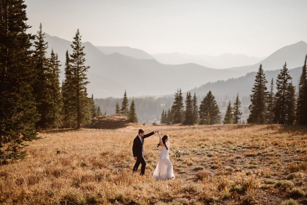 Couple dancing in a mountain meadow on their wedding day