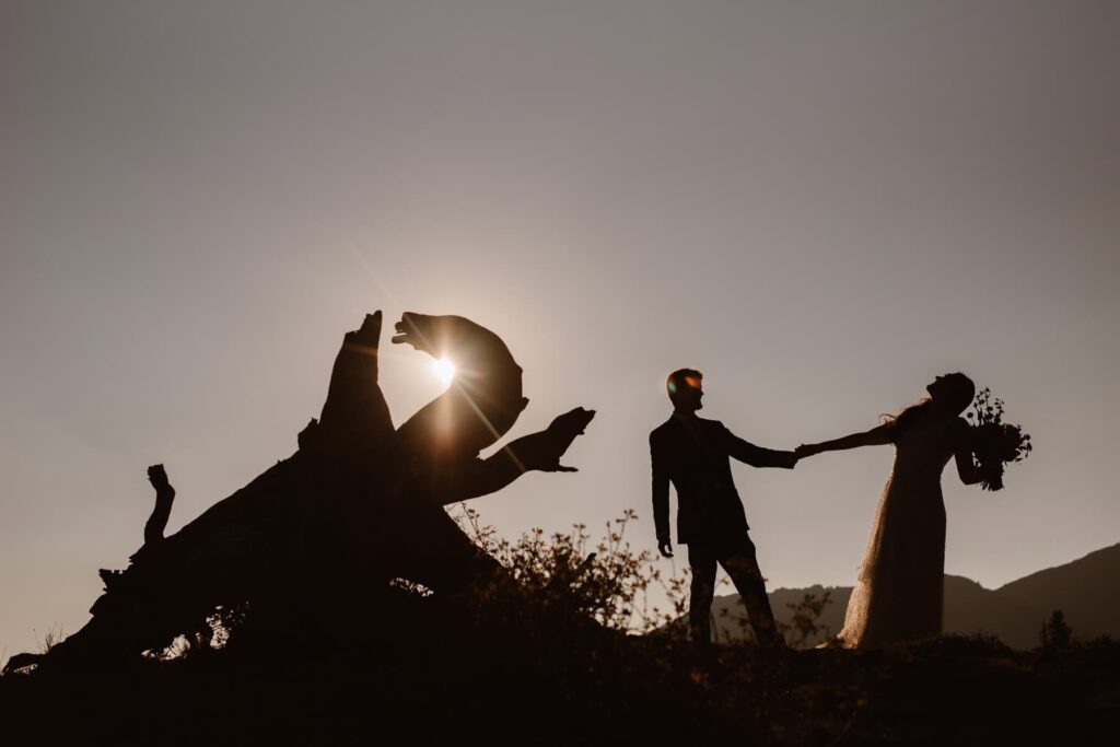 Silhouette of couple dancing in the mountains on their wedding day