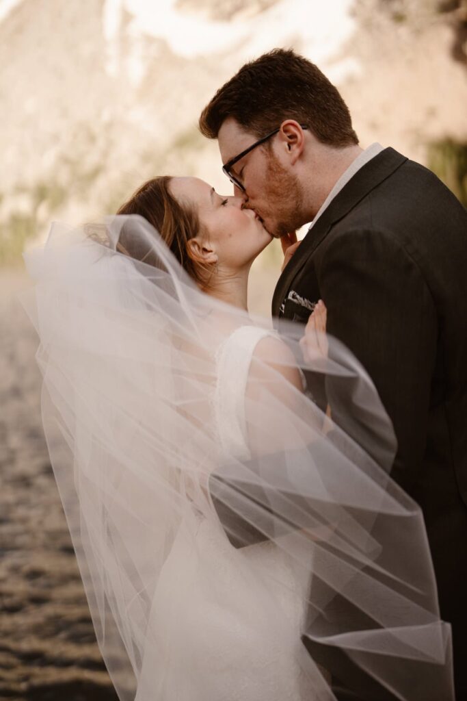 Couple shares a kiss behind the veil