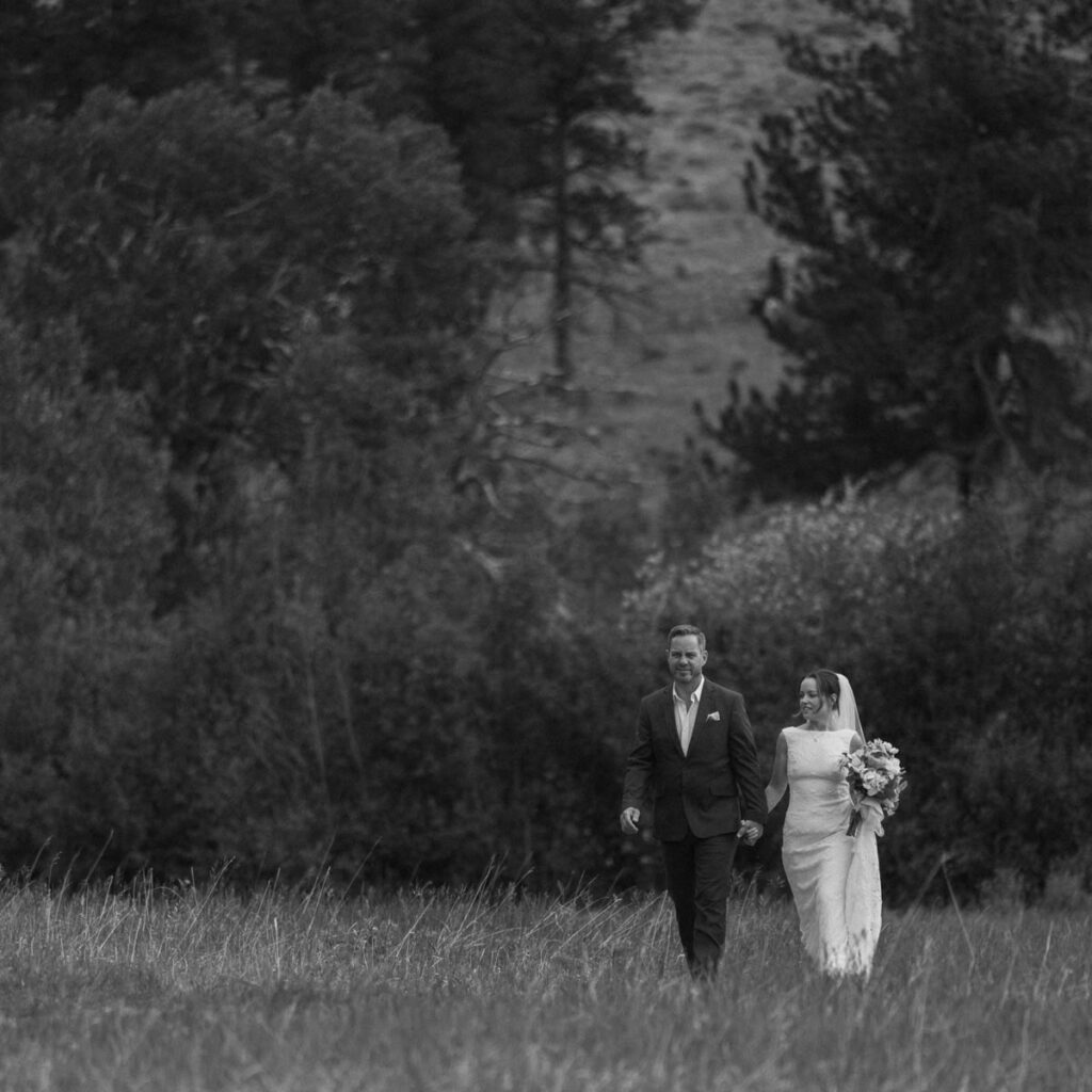 Bride and father walking through a meadow