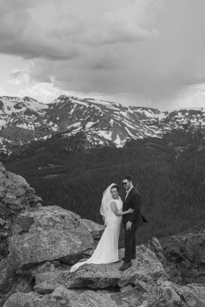 Couple standing on top of a cliff on their wedding day