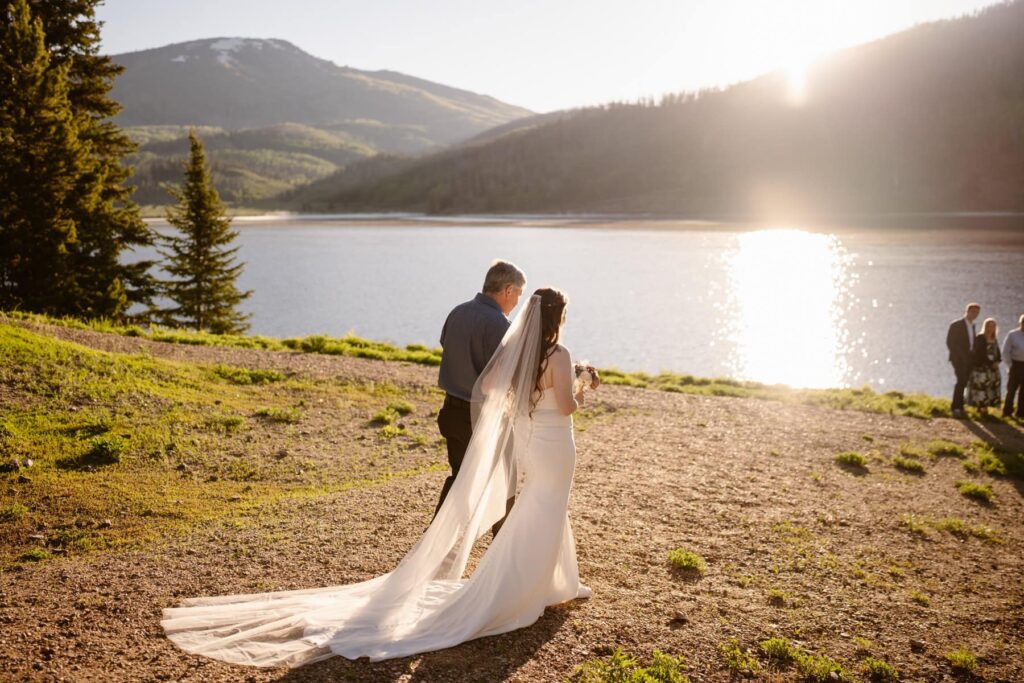 Bride and her father walking down to the shore of Pearl Lake on her wedding day