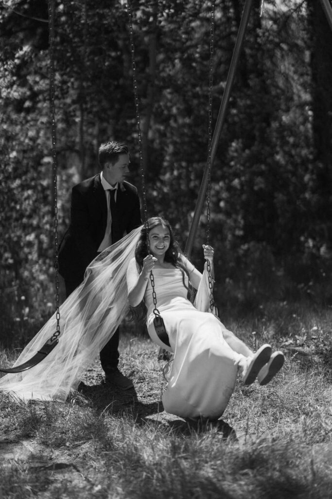 Bride and groom playing on a swing set