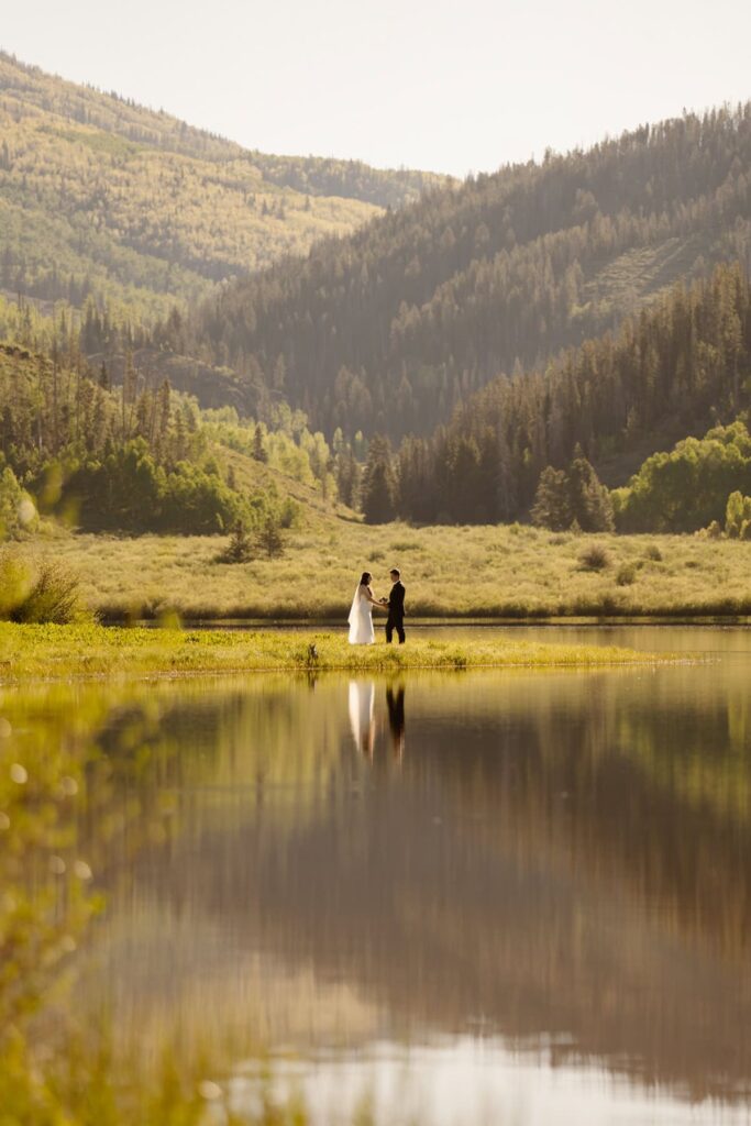 Couple dancing on the shore of a lake on their wedding day