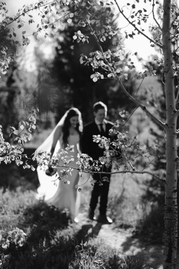 Couple hiking through an aspen grove on a dirt trail