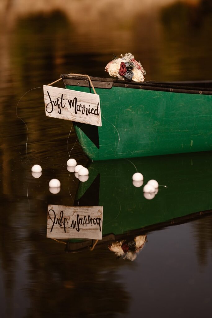 Just Married sign on the back of the canoe with wedding bouquet