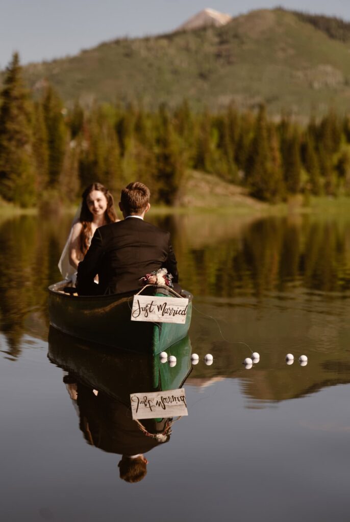 Couple in a canoe in the mountains that says Just Married