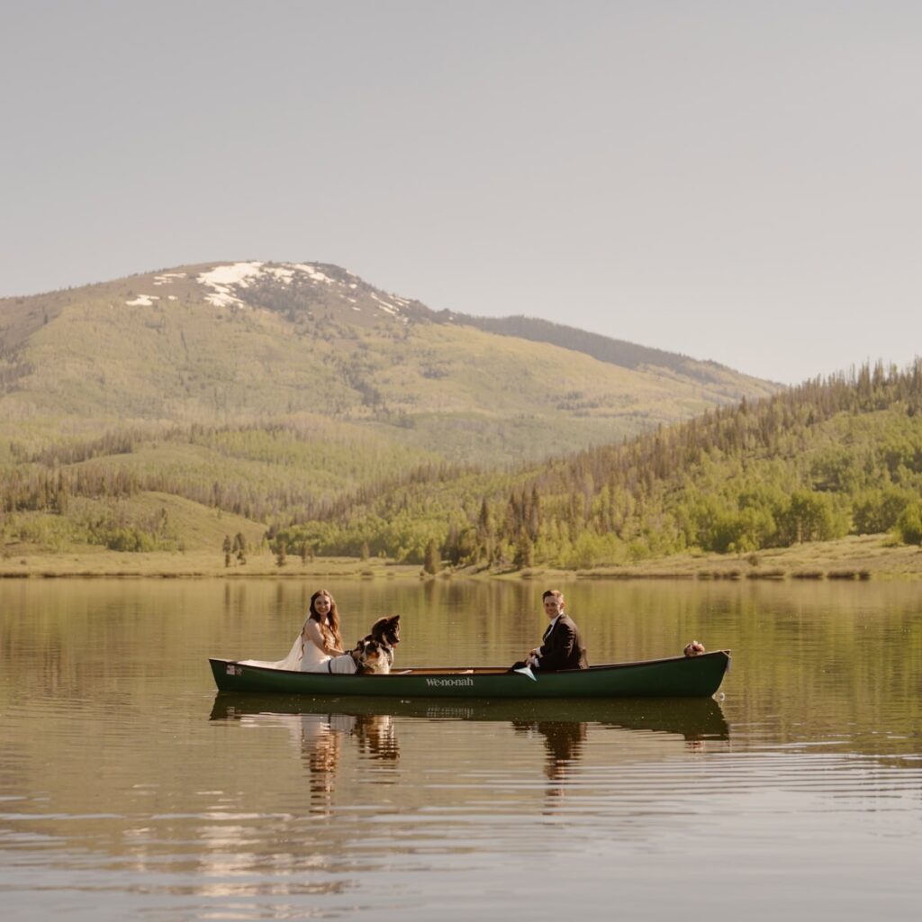 Couple with their two dogs on a canoe in the mountains