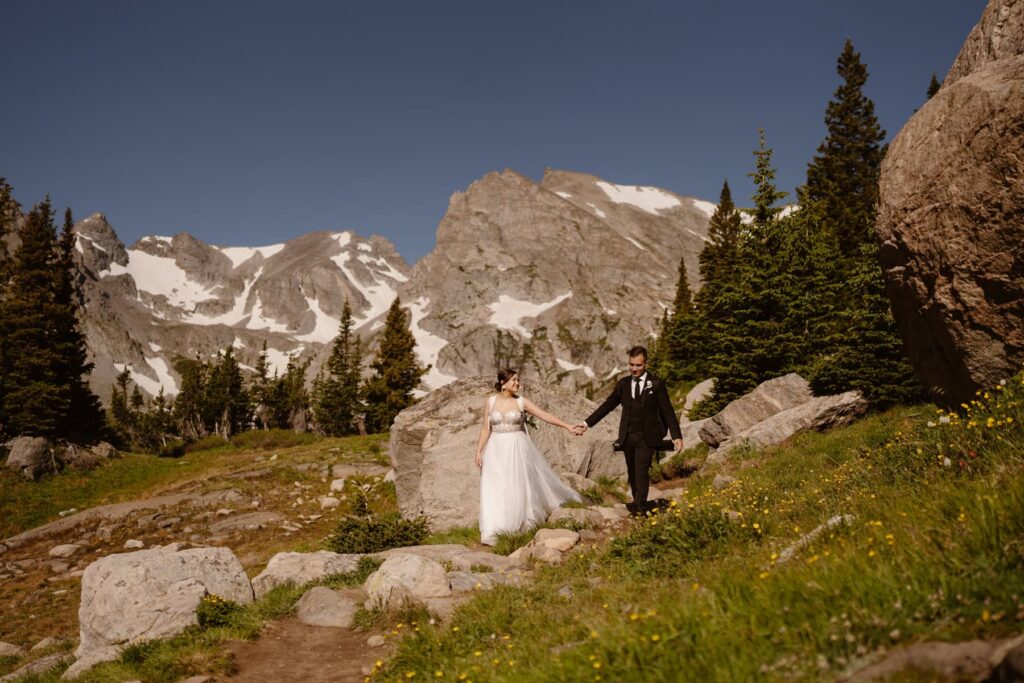 Bride and groom hiking down trail