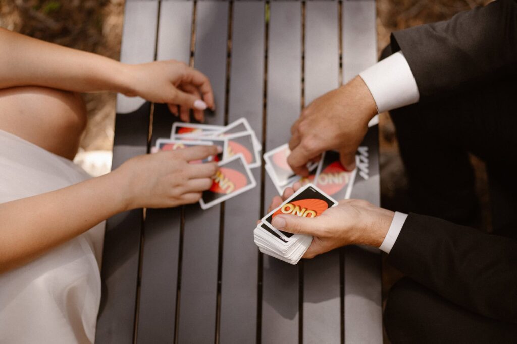 Bride and groom playing Uno in the forest