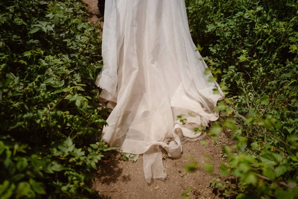 Wedding dress trailing down a dirt path