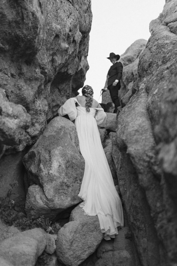 Bride climbing up a rock wall