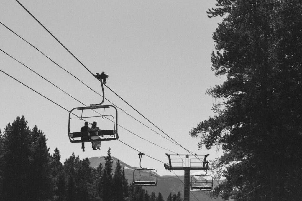 Bride and groom on ski lift on way to Crested Butte wedding site