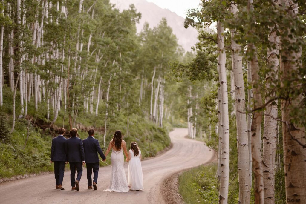 Bride, groom, and kids walking down a dirt road in Crested Butte