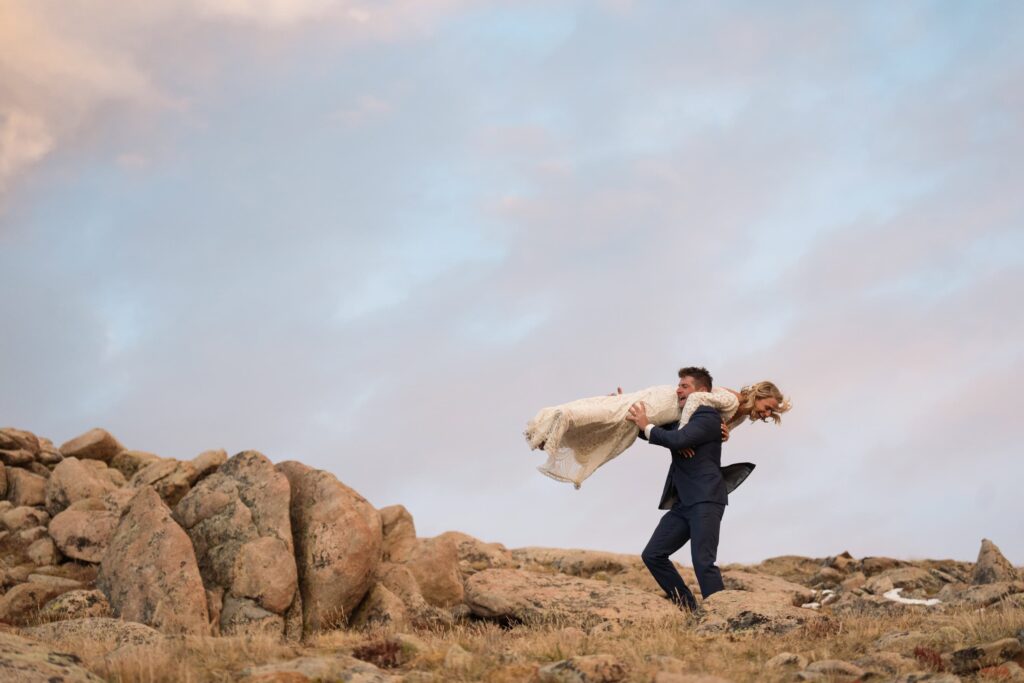 Groom carrying his bride over his shoulder