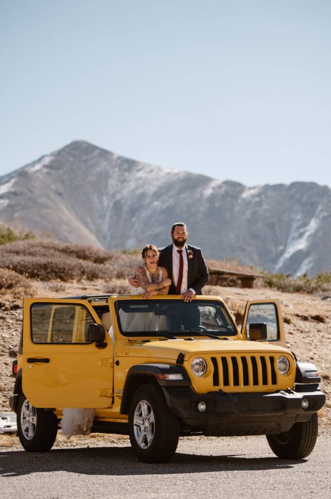 Bride and groom in yellow Jeep in Colorado