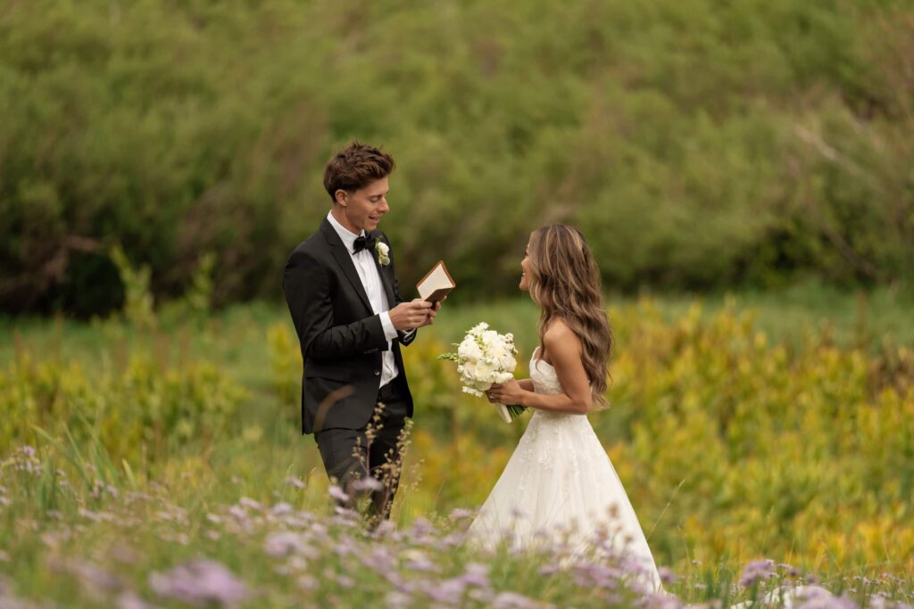 Bride and groom share private vows in a wildflower meadow