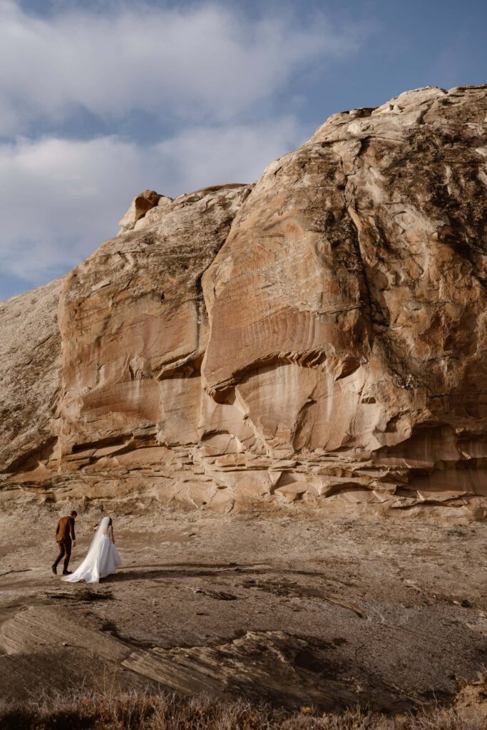Bride and groom walking desert landscape at Amangiri