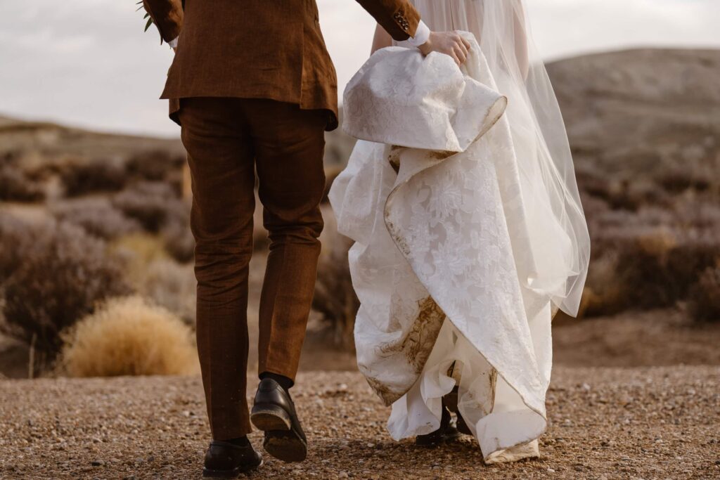 Groom lifting bride's dress