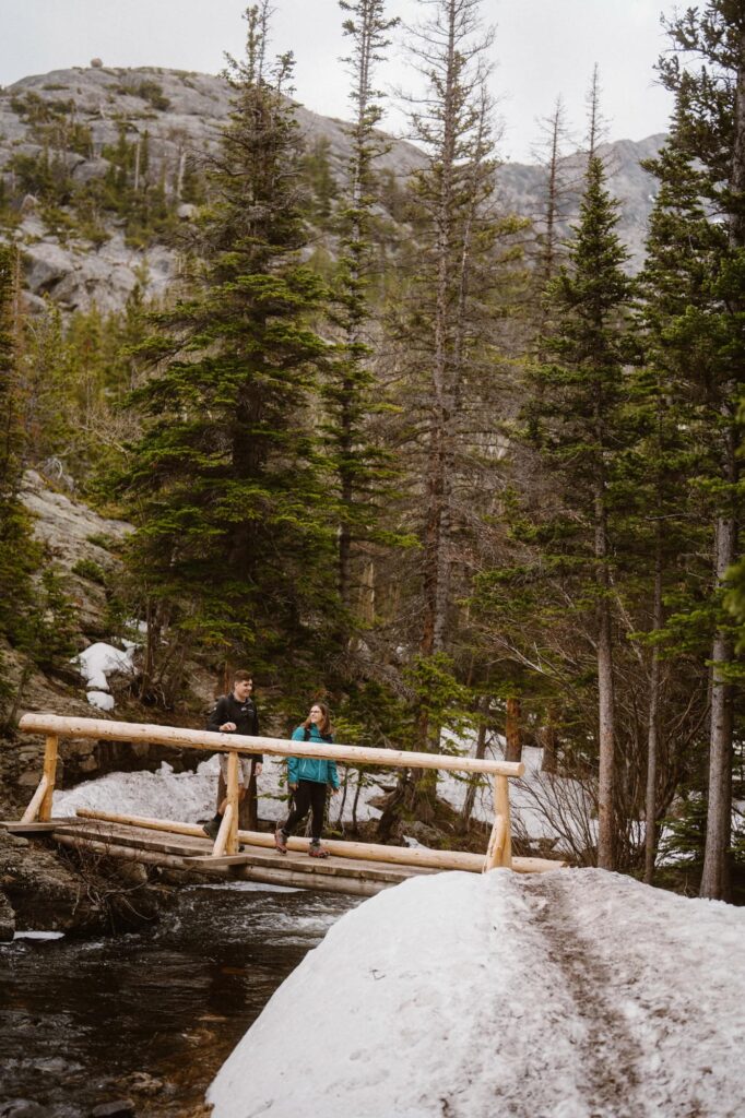 Couple hiking across a bridge in Rocky Mountain