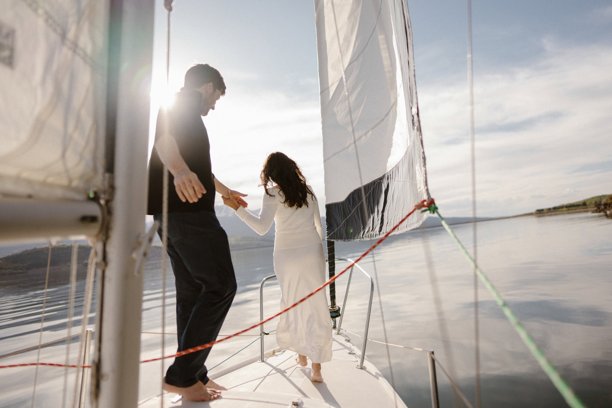 Couple holding hands and walking down sailboat