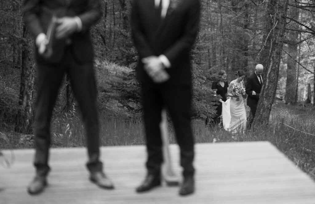 Bride walking down the aisle through the woods