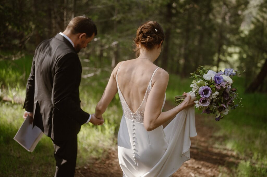 Bride and groom walking down dirt path at Juniper Mountain House wedding