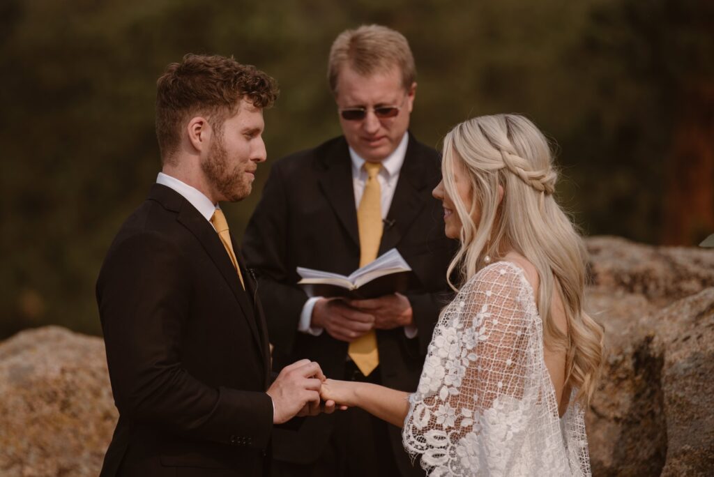 Couple exchanging rings during outdoor wedding ceremony