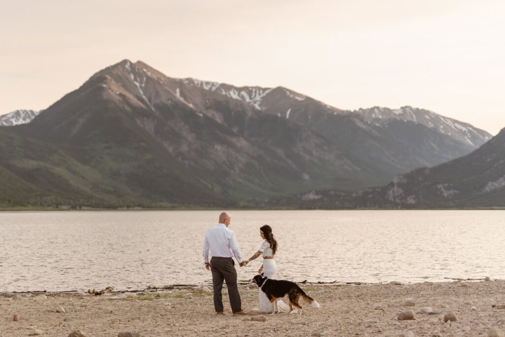 Bride, groom, and their dog on the shore of Twin Lakes in Colroado