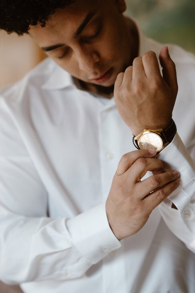 Groom putting on his watch for before his elopement day