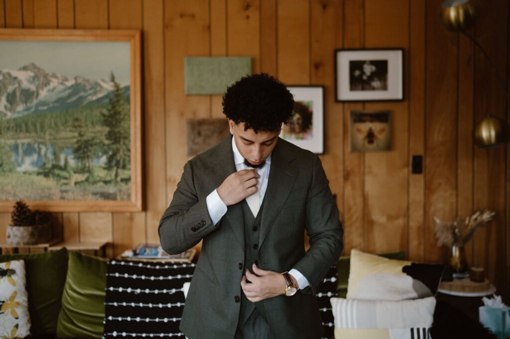 Groom getting ready for Grand Lake elopement at cute Airbnb