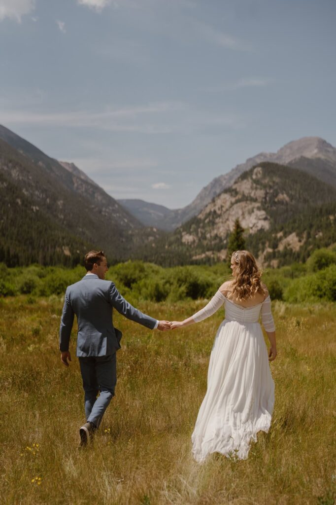 Bride and groom in mountain meadow in Estes Park