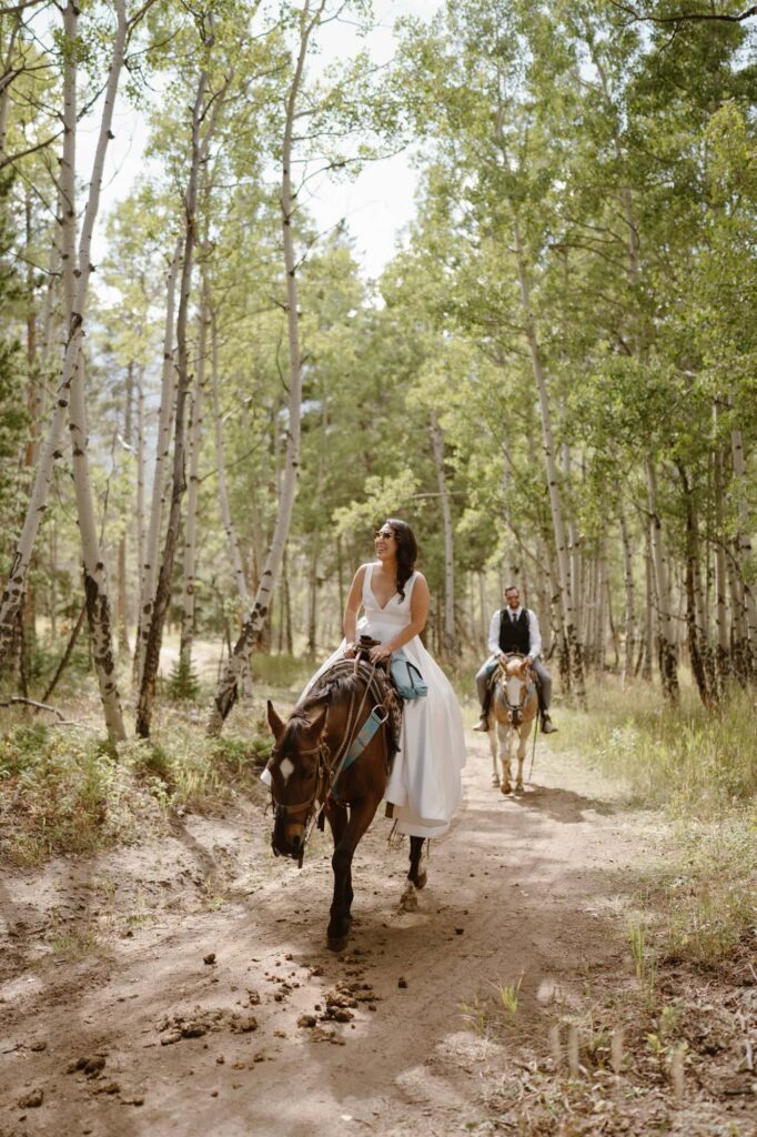 Romantic horseback riding wedding photos through an aspen grove