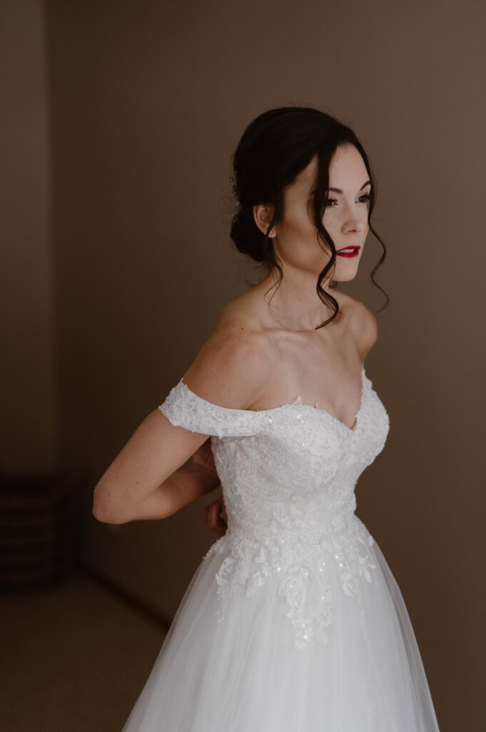 Bride getting into wedding dress before winter Colorado wedding