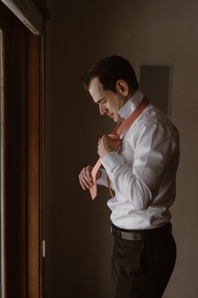 Groom with a salmon tie and black suit