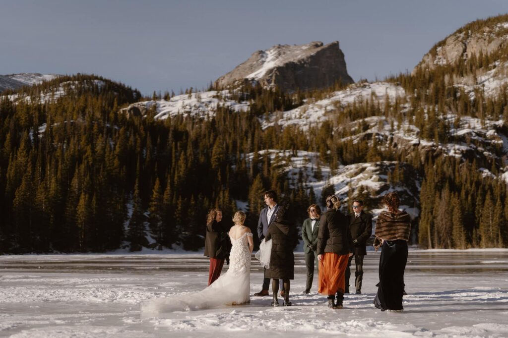 Couple standing on frozen Bear Lake with family during wedding ceremony