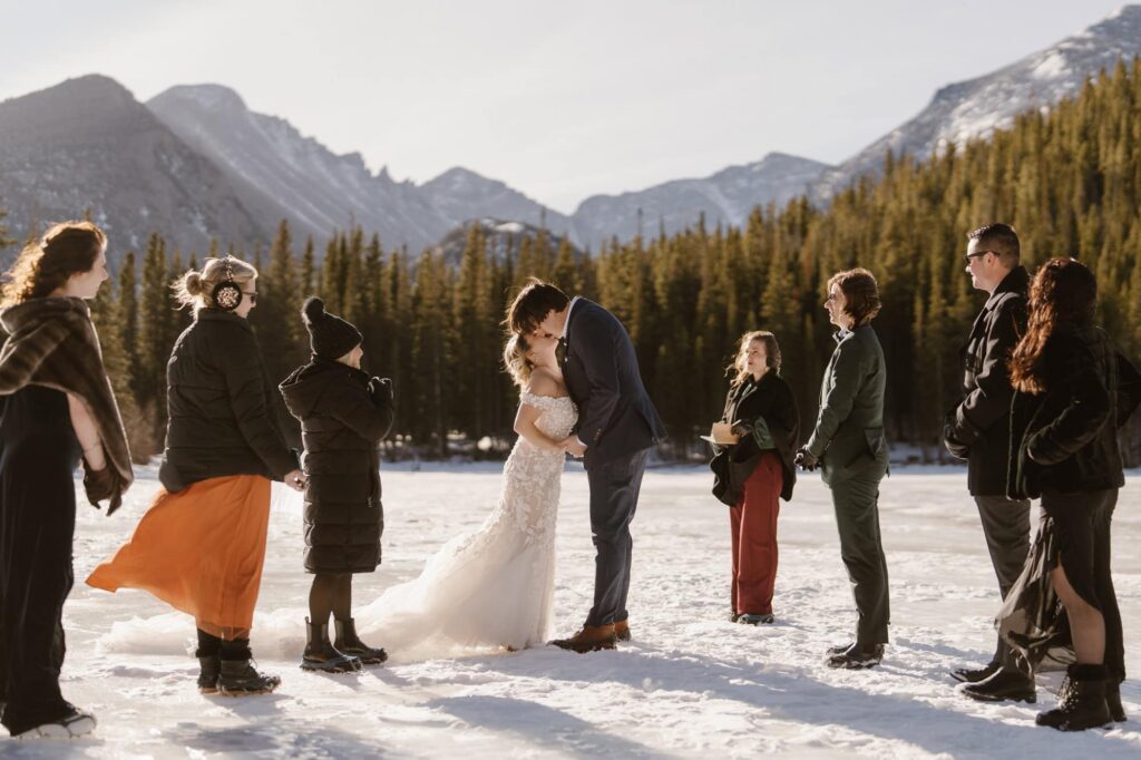 First kiss during outdoor winter wedding ceremony