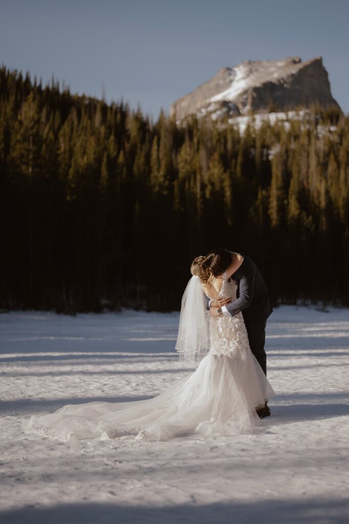 Bride and groom hugging after first look on a frozen mountain lake